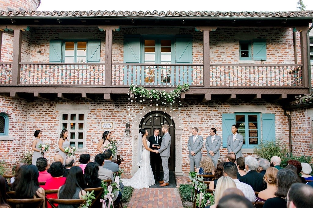 Casa-Feliz-Outdoor wedding with bride and groom standing in archway in front of brick building