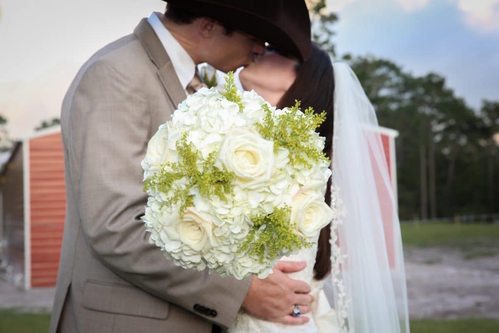 country bride and groom kissing near barn at the Diamond L Venue in Volusia County, near Deltona, FL
