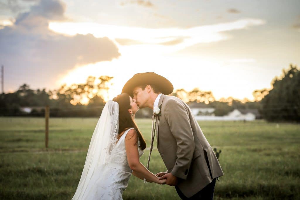country bride and groom kissing in field at the Diamond L Venue in Volusia County, near Deltona, FL