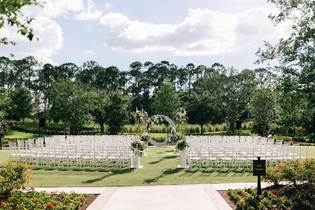 wedding ceremony set up on the lawn, all white chairs, outdoors, clear skies, Central Florida