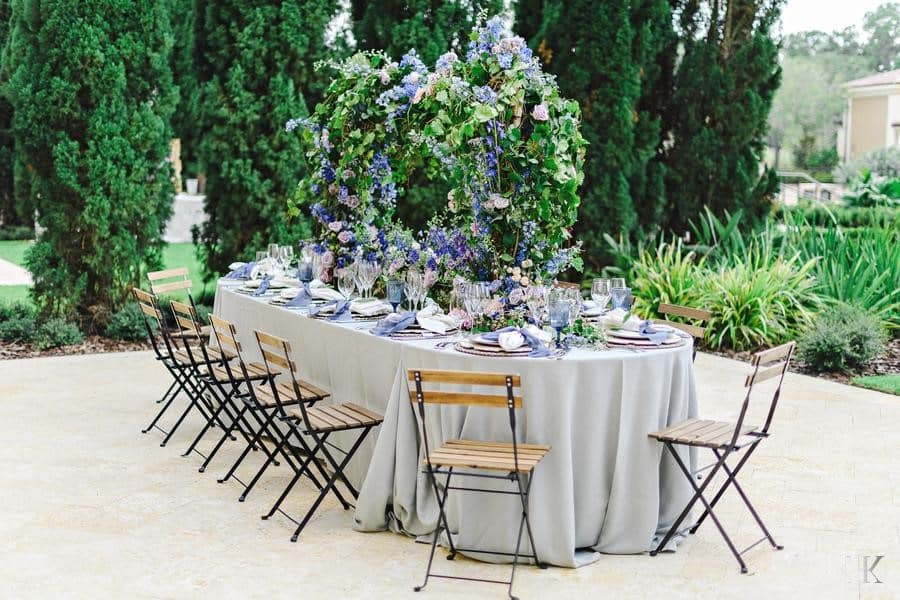 lavender and green floral centerpiece, reception table, with a light lavender tablecloth, greenery around the terrace area, Orlando