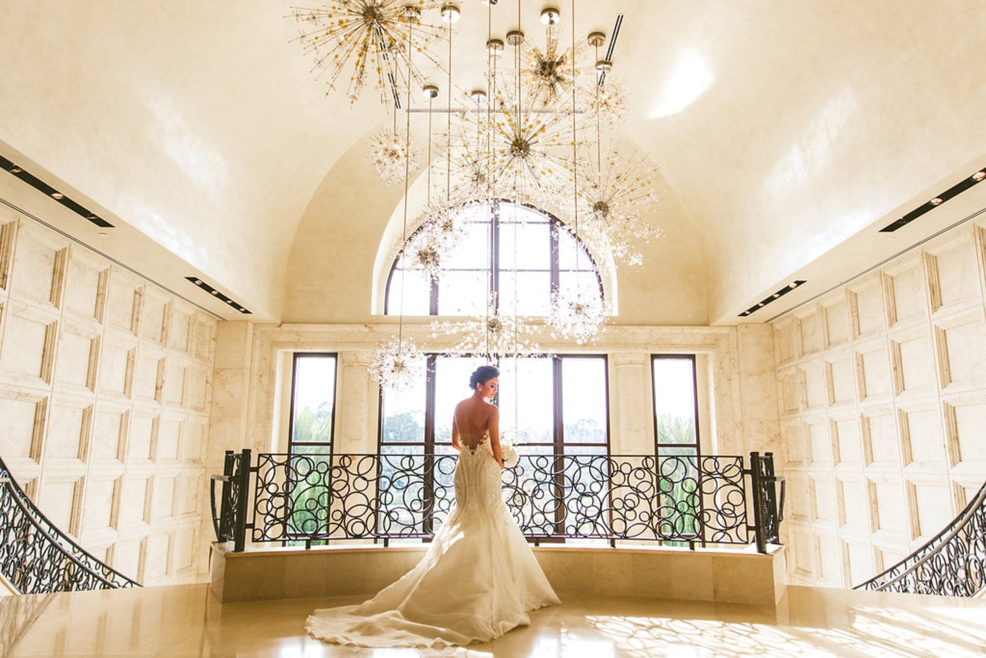 Four-Seasons-at-Walt-Disney-World- Bride standing at the top of a grand staircase in front of large windows