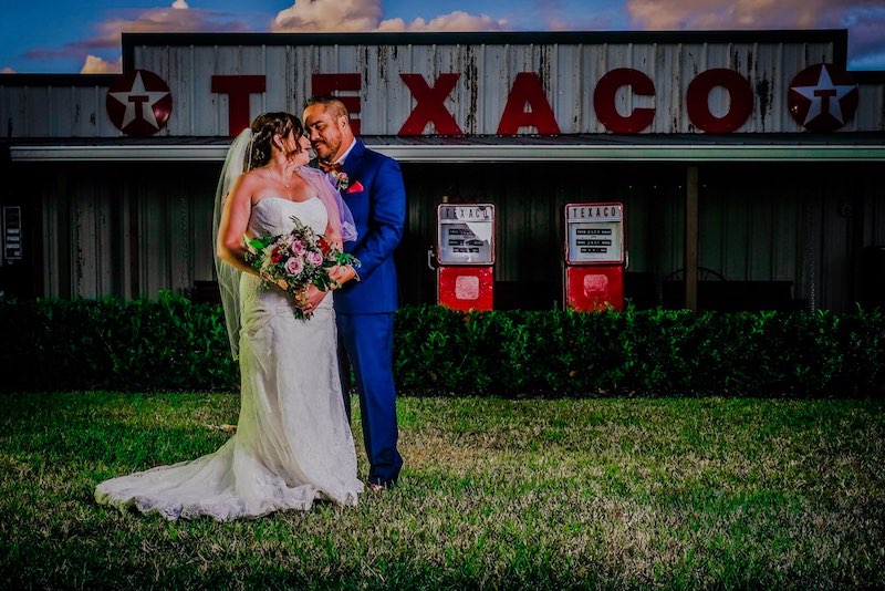 Hidden Barn bride and groom embracing in front of iconic Texaco station