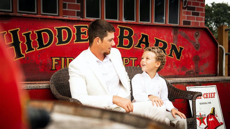 Hidden Barn father and son sitting in front of Hidden Barn Fire Dept. sign