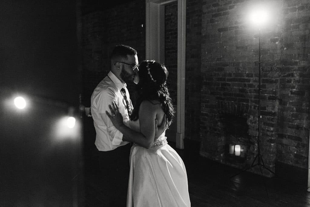 black and white photo of bride and groom dancing alone