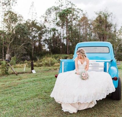 bride on antique blue truck at mystical winds