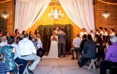 Mystical Winds bride and groom getting married inside under chandelier with guests watching