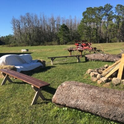 Mystical Winds daytime look at outside of venue with benches and hay bails and a bonfire setup