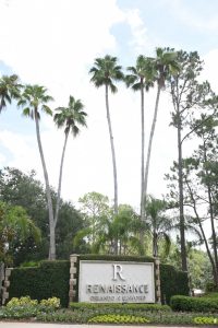 sign at entrance to renaissance orlando hotel at seaworld with tall palm trees behind it