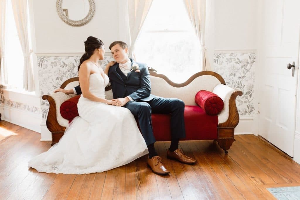 The-Highland-Manor-Bride and Groom enjoying a moment together on a red velvet couch