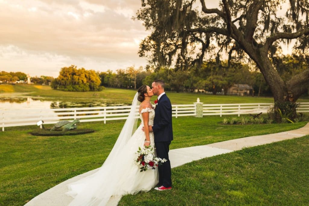 The-Highland-Manor-Bride and Groom kissing outdoors in front of white fence