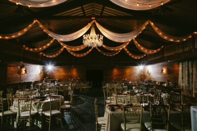Dark lit venue space with a chandelier and wooden walls