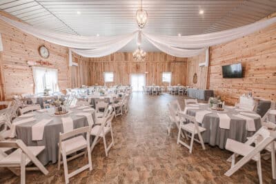 Beautiful rustic venue set up with gray and white linens ready for a wedding reception