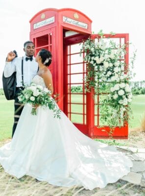 Bride and Groom standing outside a red phone booth, white roses, The Royal Crest Room, Orlando, FL