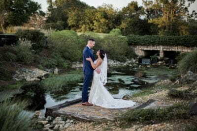 Bride and Groom standing near a creek with a small waterfall, countryside, Orlando, FL