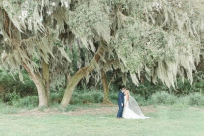 bride and groom standing in a field, trees surrounding them, Orlando, FL