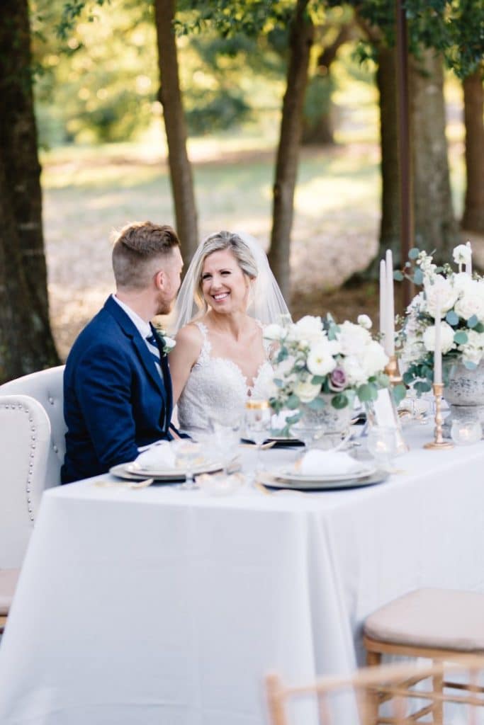 Wedding couple at outdoor table celebrating