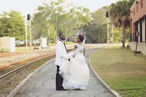 bride and groom looking over their shoulders, outdoors, walking on a concrete path, Orlando, FL
