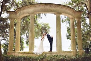 Rhodes Studios, photography and Video, bride and groom kissing underneath stone arch, Orlando, FL