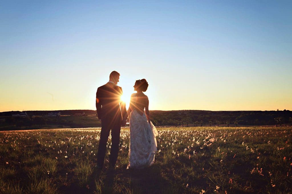 Rhodes Studios Photography and Video - back of bride and groom with setting sun