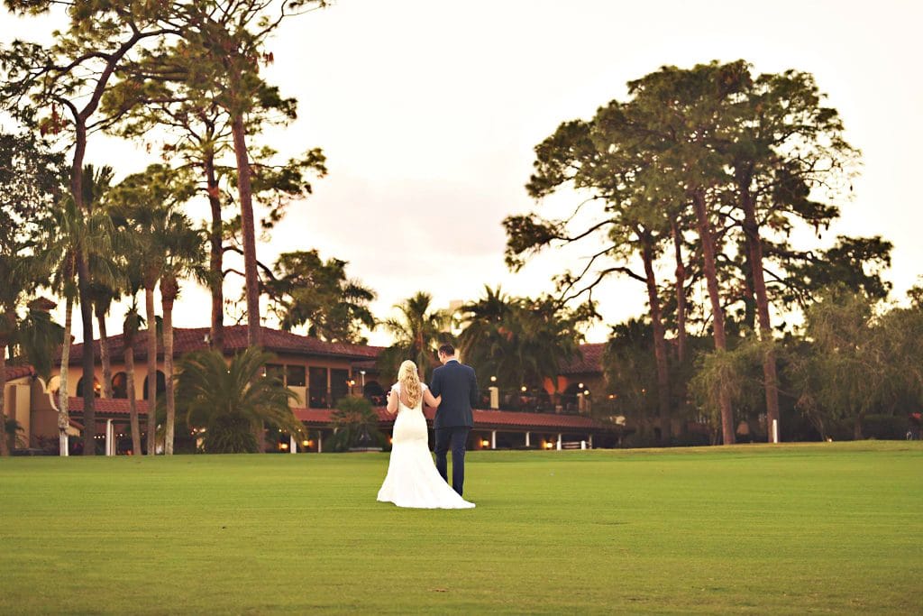 Rhodes Studios Photography and Video - bride and groom walking away across golf course