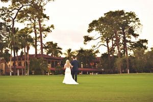 bride and groom walking away across golf course, closing in on sunset, Orlando, FL