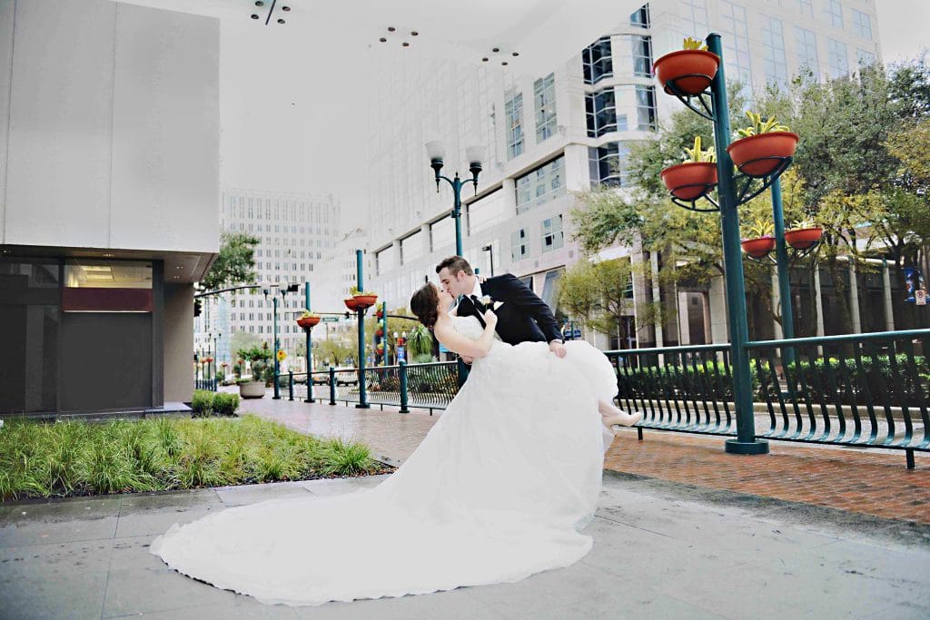 Rhodes Studios Photography and Video - groom dipping and kissing bride on city street