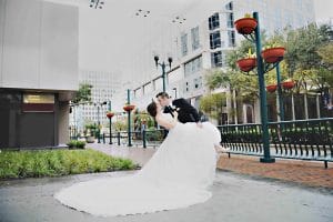 Rhodes Studios, groom dipping and kissing bride on city street, Orlando, FL