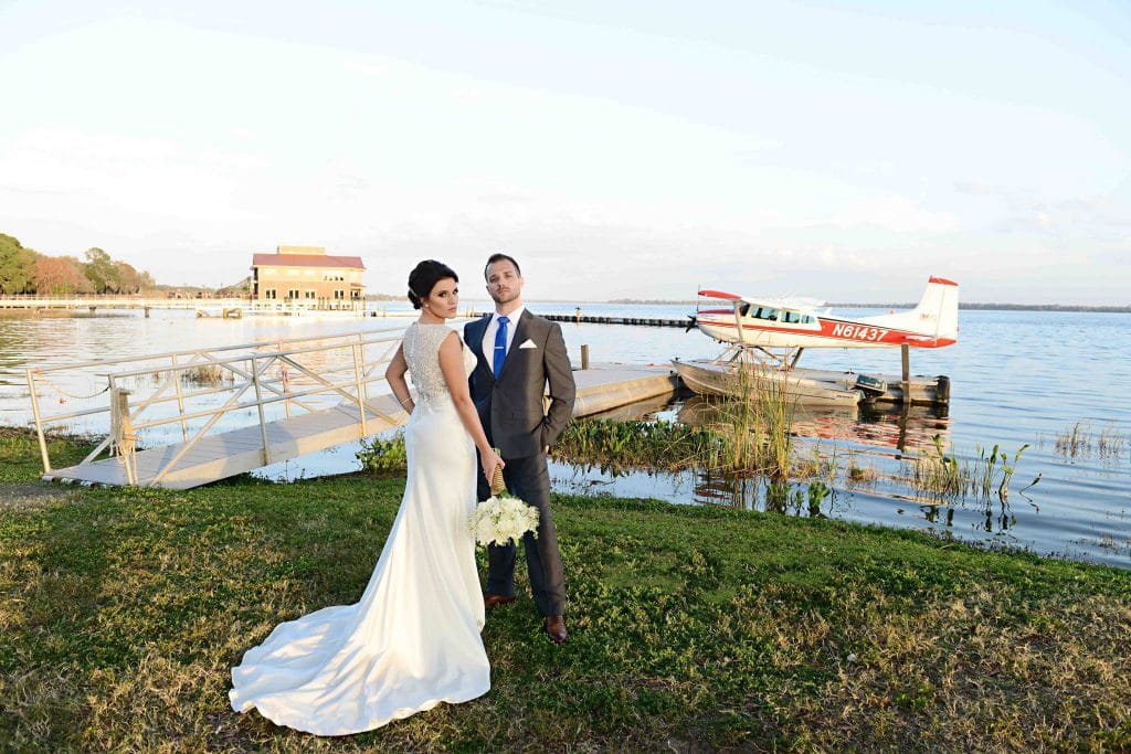Rhodes Studios Photography and Video - bride and groom posing next to seaplane