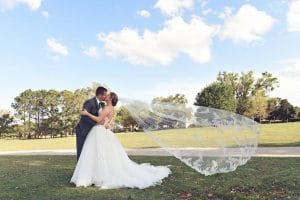 Rhodes Studios, photography and Video, bride and groom kissing while wind blows veil, Orlando, FL