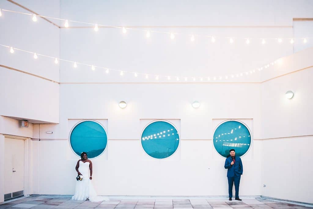 Rudy & Marta Photography - bride and groom in front of modern circular windows