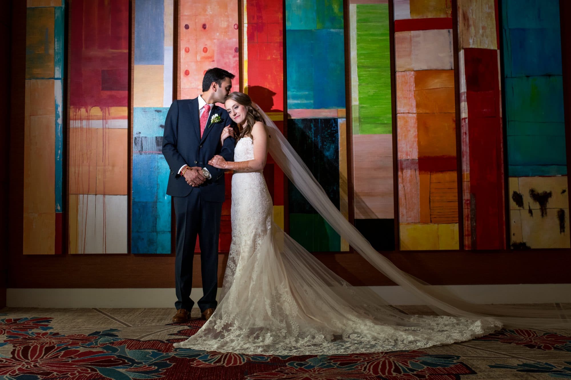 bride and groom posing in front of color block wall