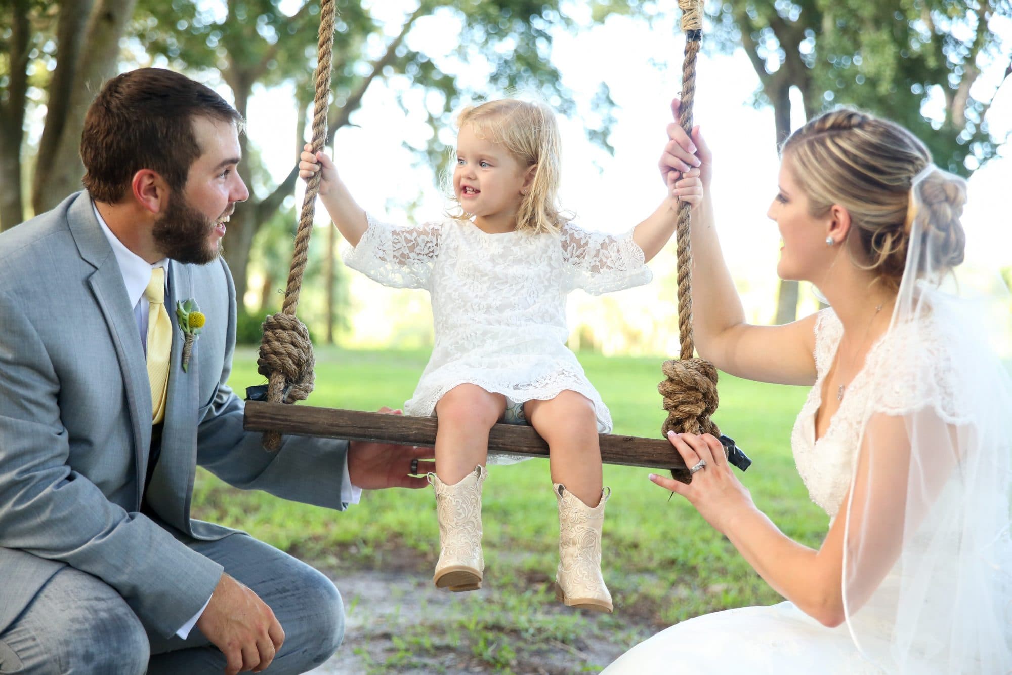 bride and groom swing toddler girl on swing
