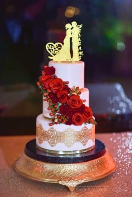 Everything Cake - white cake with cascade of red blooms and gold lace accent around the bottom