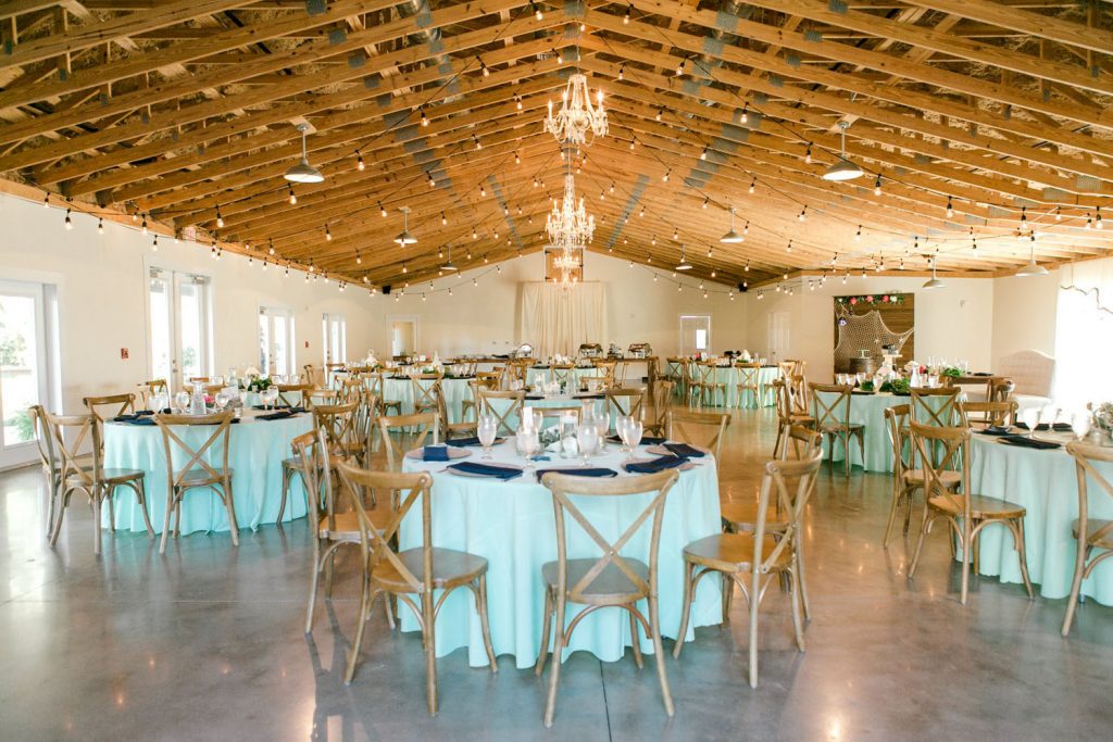 lovely reception hall with wooden rafters and chandeliers by Bumby Photography