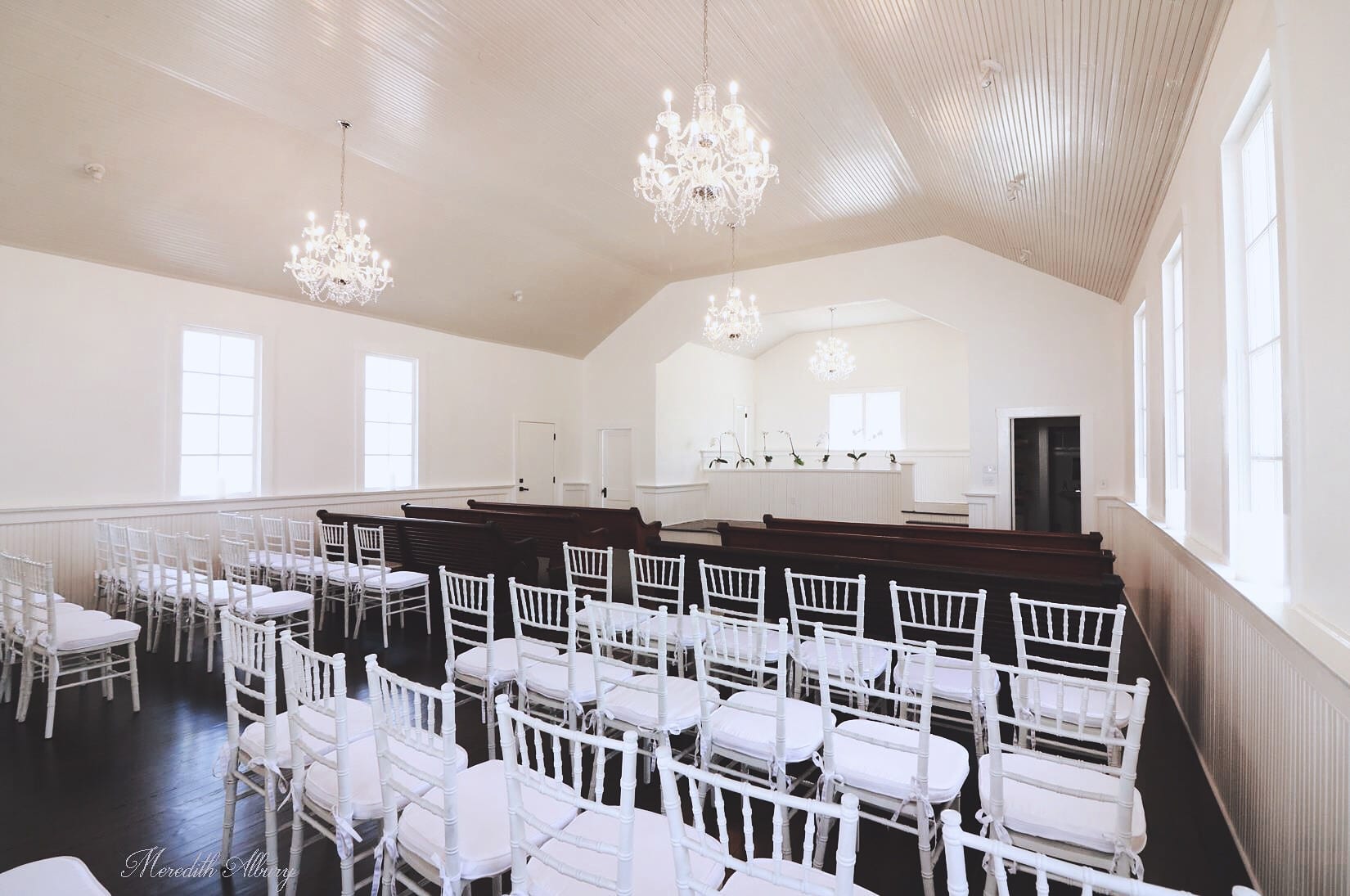 Chapel & Hudson's Cellar - all-white chapel with dark pews and white chiavari chairs