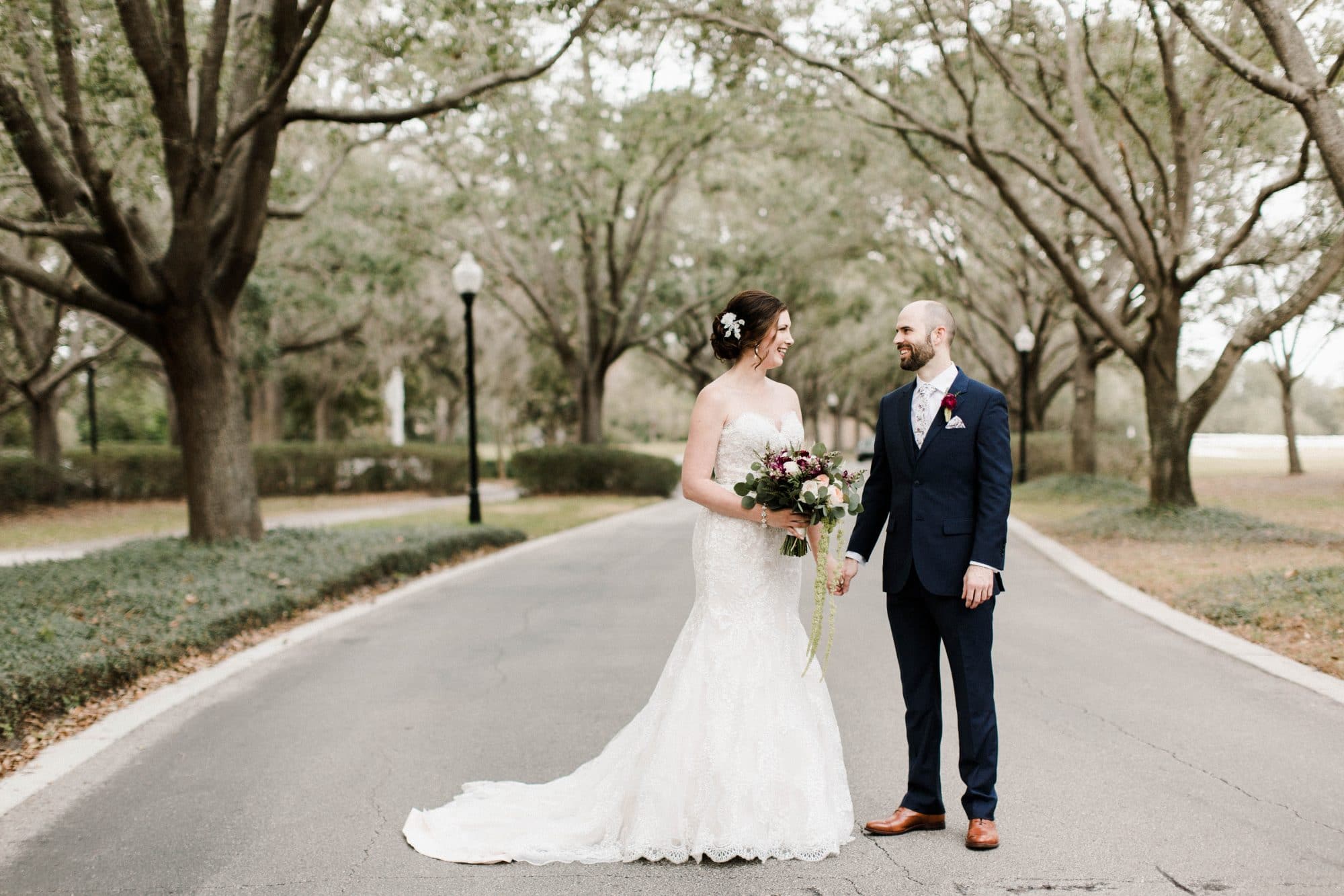 Cypress Grove Estate House - bride and groom in tree-lined street