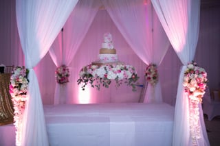Enchanted Nights - wedding cake set up on curtain-lined dais