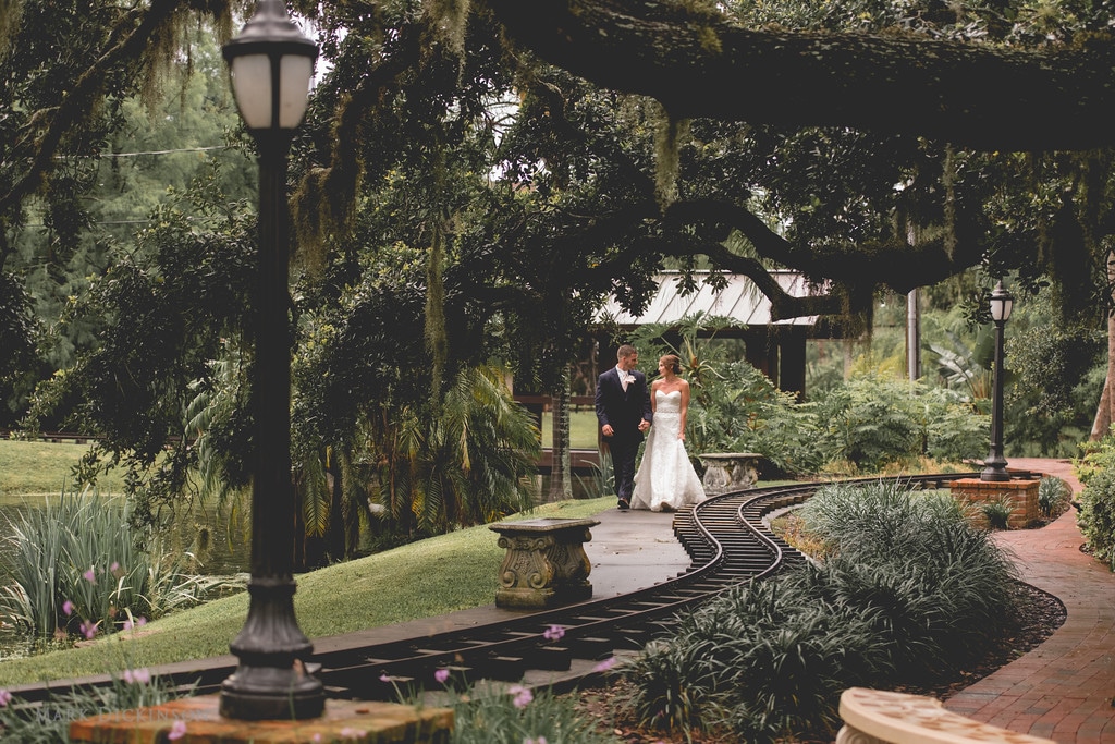 Estate on the Halifax - bride and groom walking through lush grounds next to small train track