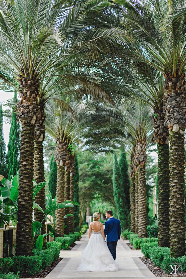 Four Seasons Resort Orlando - couple walking down palm tree-lined sidewalk