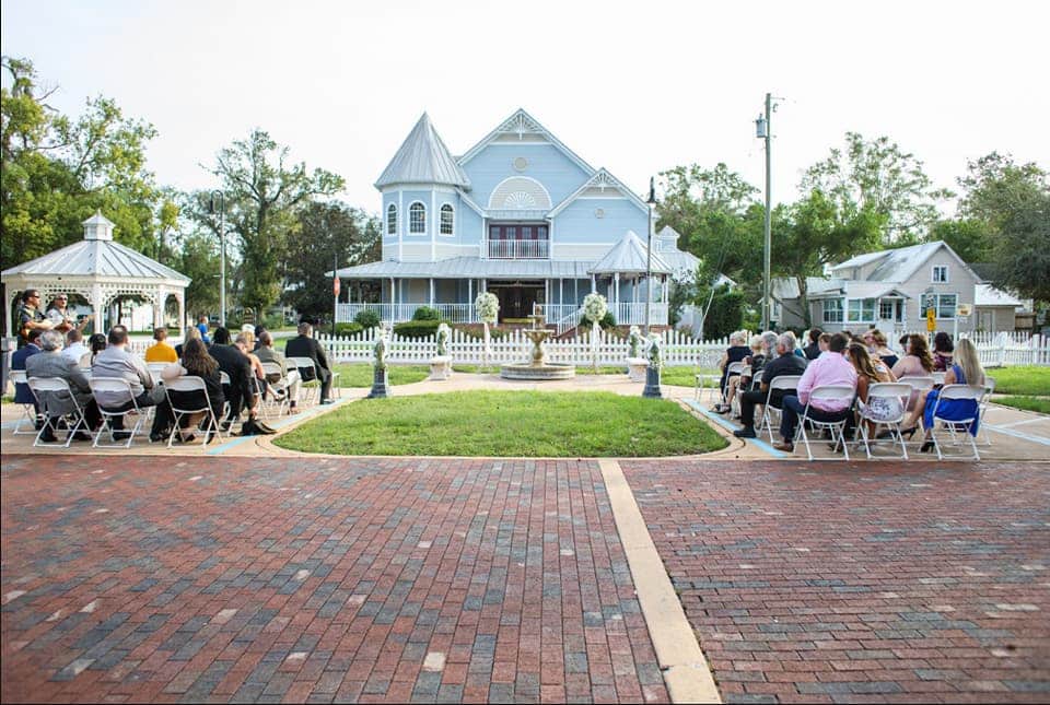 Longwood Community Building - outdoor ceremony backed by cute, blue Victorian house