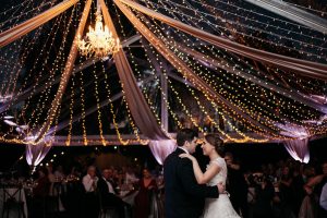 Rentaland Tents and Events - transparent outdoor tent with chandelier, lights, and draping on ceiling