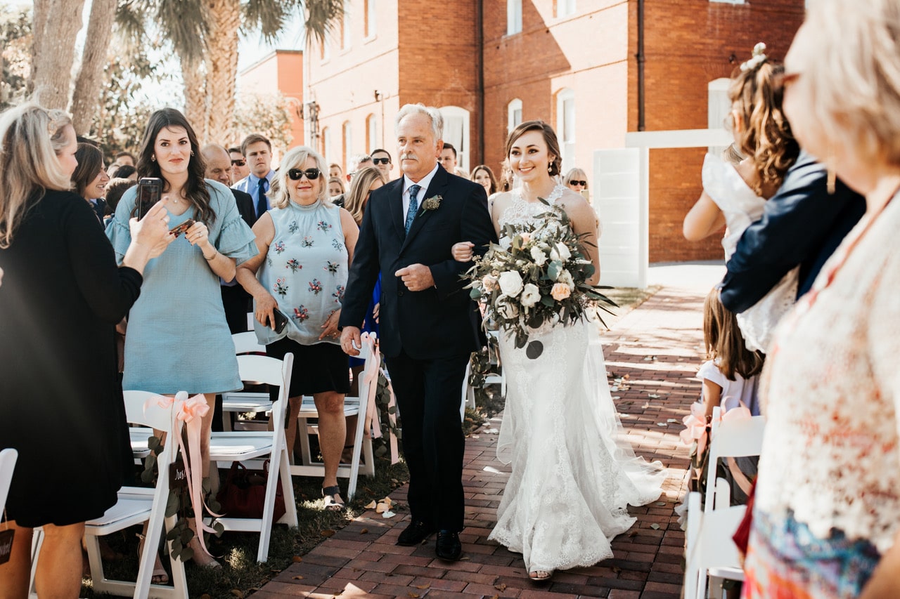 Venue 1902 at Preservation Hall - bride and father walking down brick path at ceremony