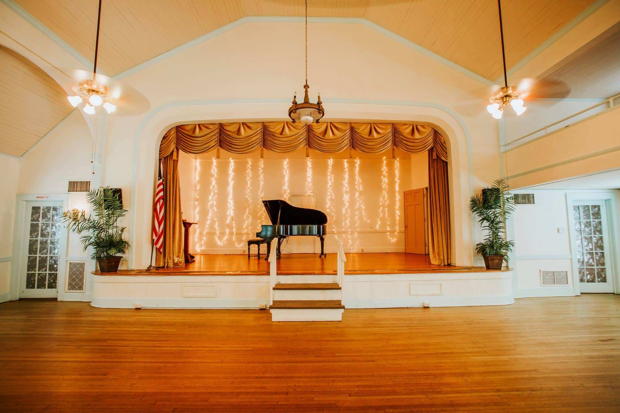 Women's Club of Sanford - reception hall with vaulted, arched ceilings, wood floors, and stage