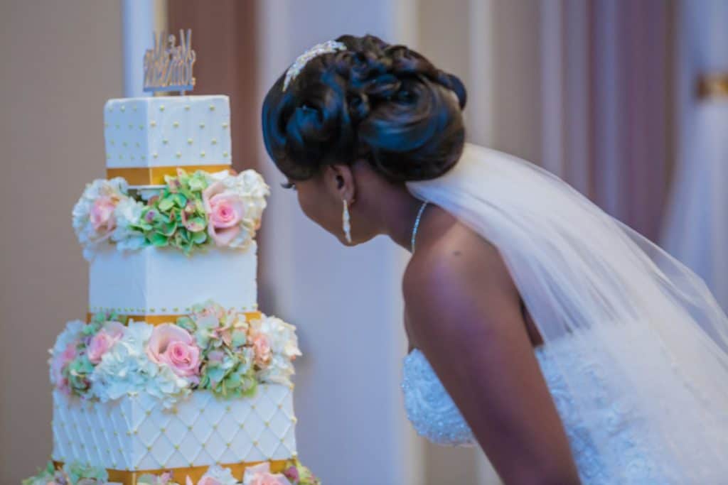 With This Ring - bride examining pink and gold wedding cake