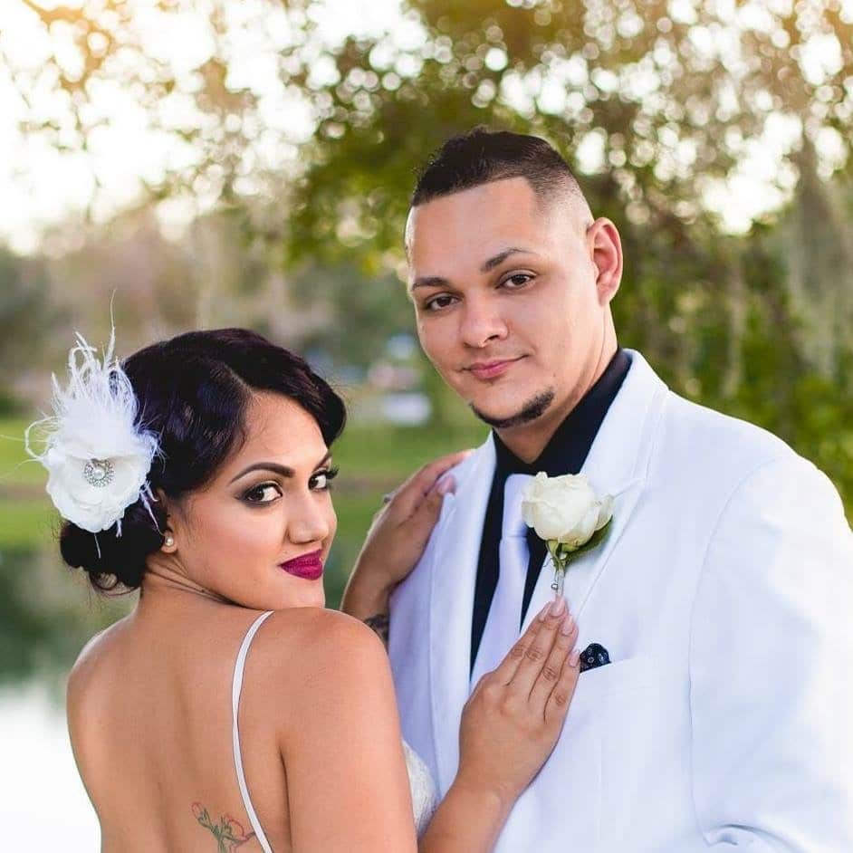 bride with feather hair piece and groom in white dinner jacket after wedding performed by Hearts & Souls Officiant an Orlando Wedding Officiant