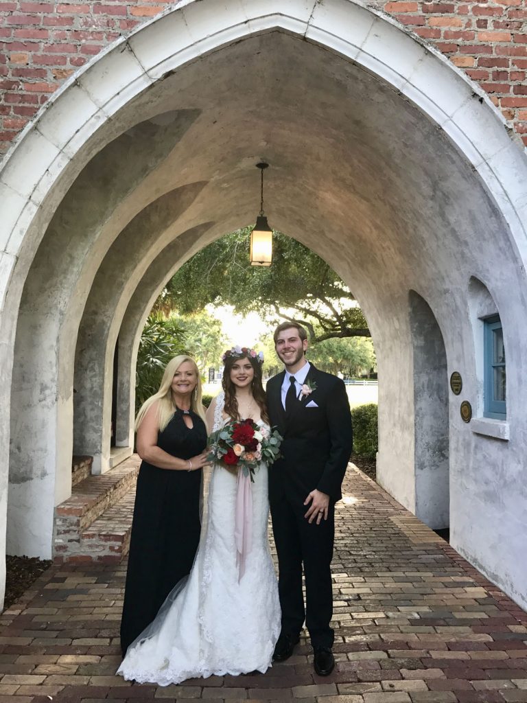 bride and groom with Hearts & Souls Officiant an Orlando Wedding Officiant under stone archway