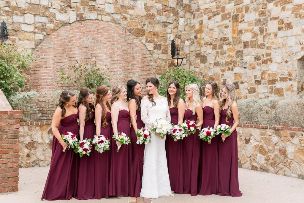 bride and bridesmaids in burgandy dresses of varying styles