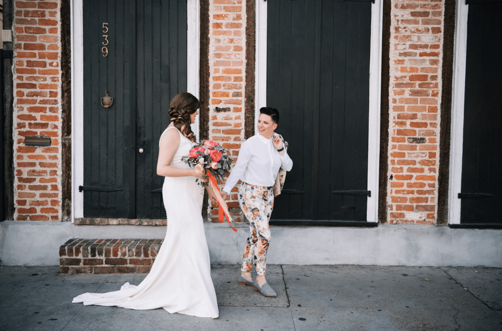 two brides in front of brick building with black doors