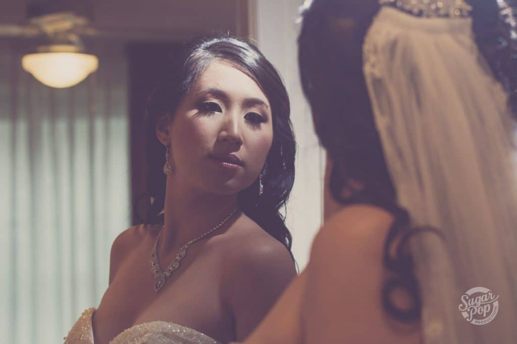 Sugar Pop Productions - Bride looking at herself in the mirror.